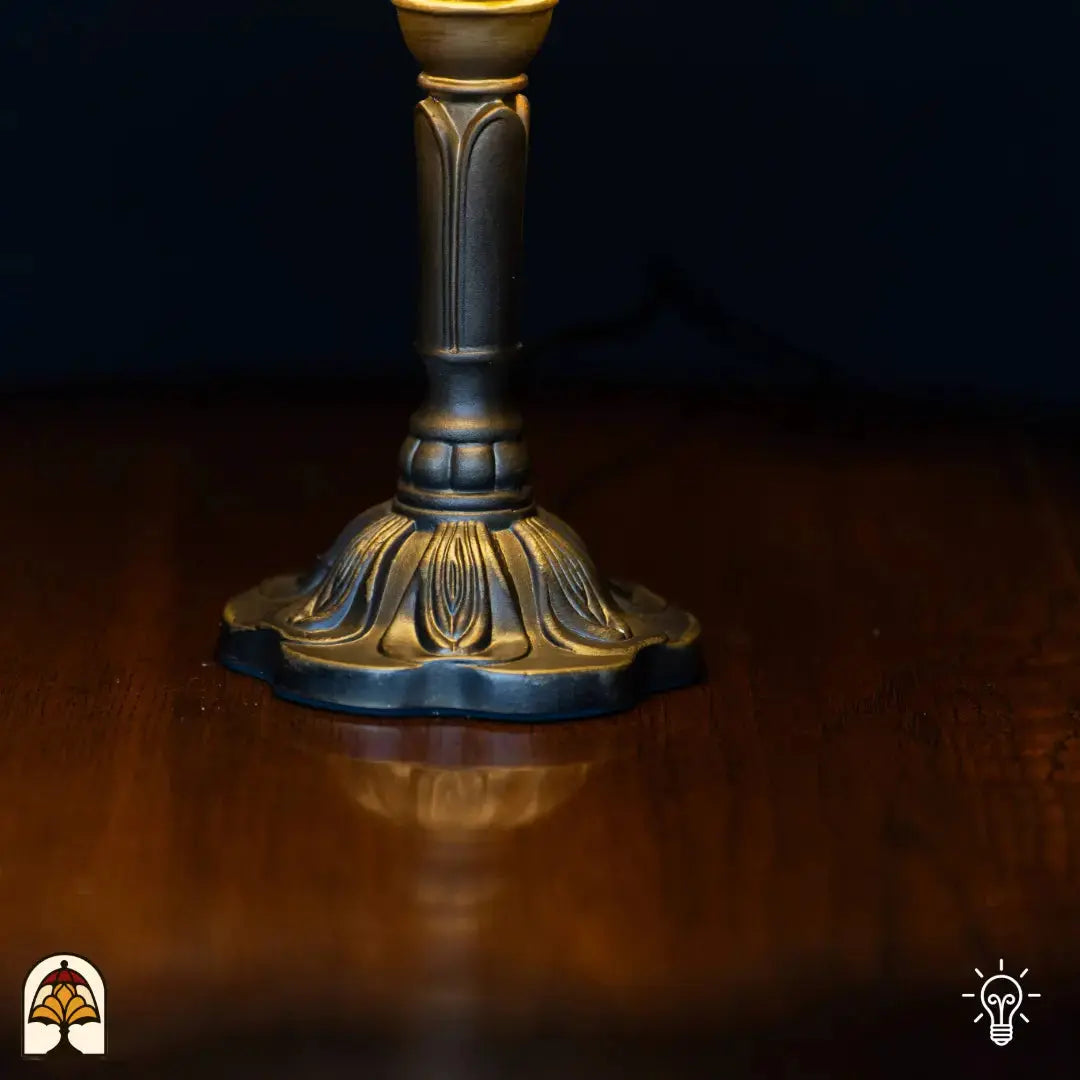 Gros plan pied vase élancé en bronze lampe de table Tiffany Rosalia Verde avec motifs de feuilles gravés sur base ronde quadrilobée