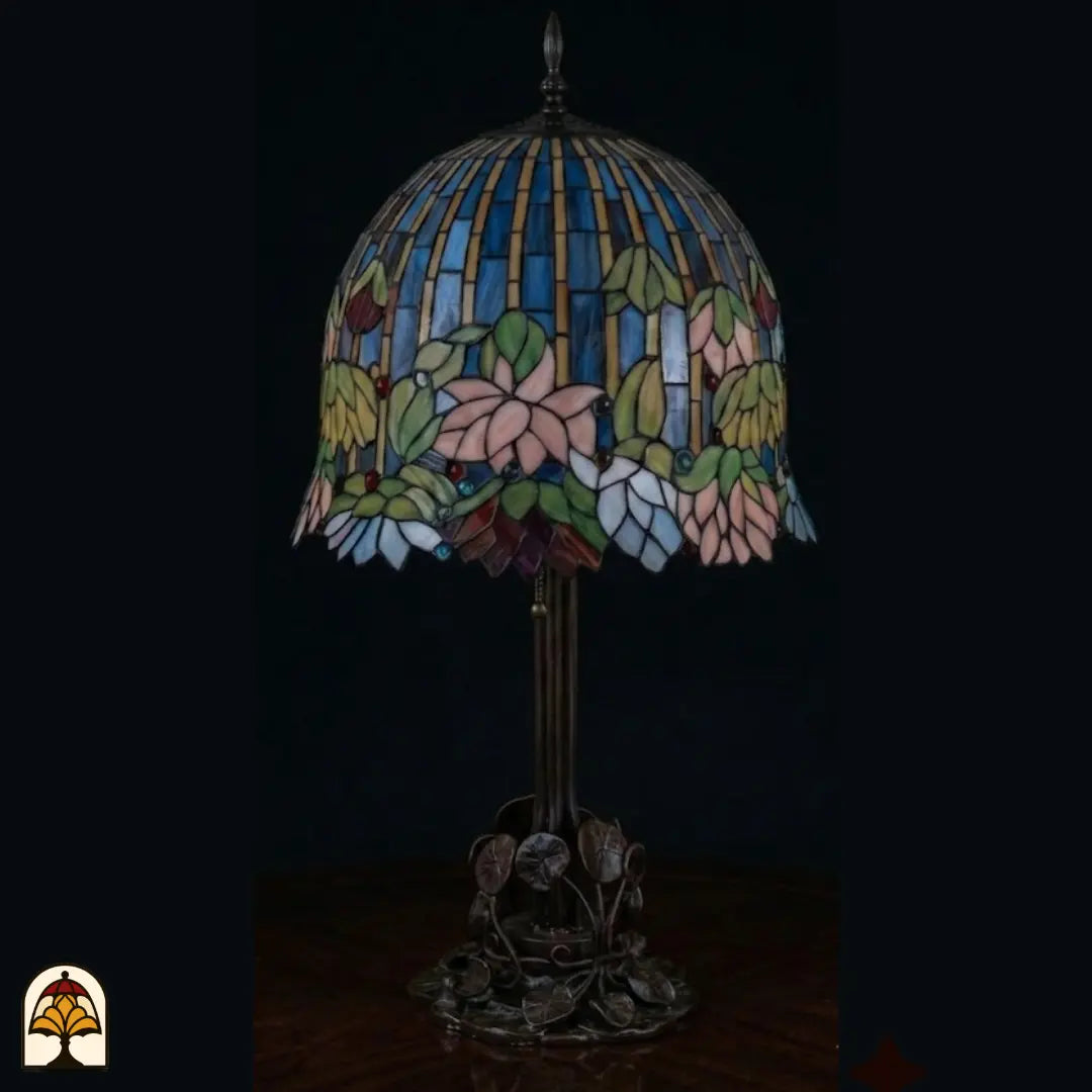 Lampe de table Tiffany Pond Lilia ⌀40 cm éteinte – nénuphar rose en couleurs à la lumière du jour, bandes de vitrail bleues et jaunes, pied en bronze