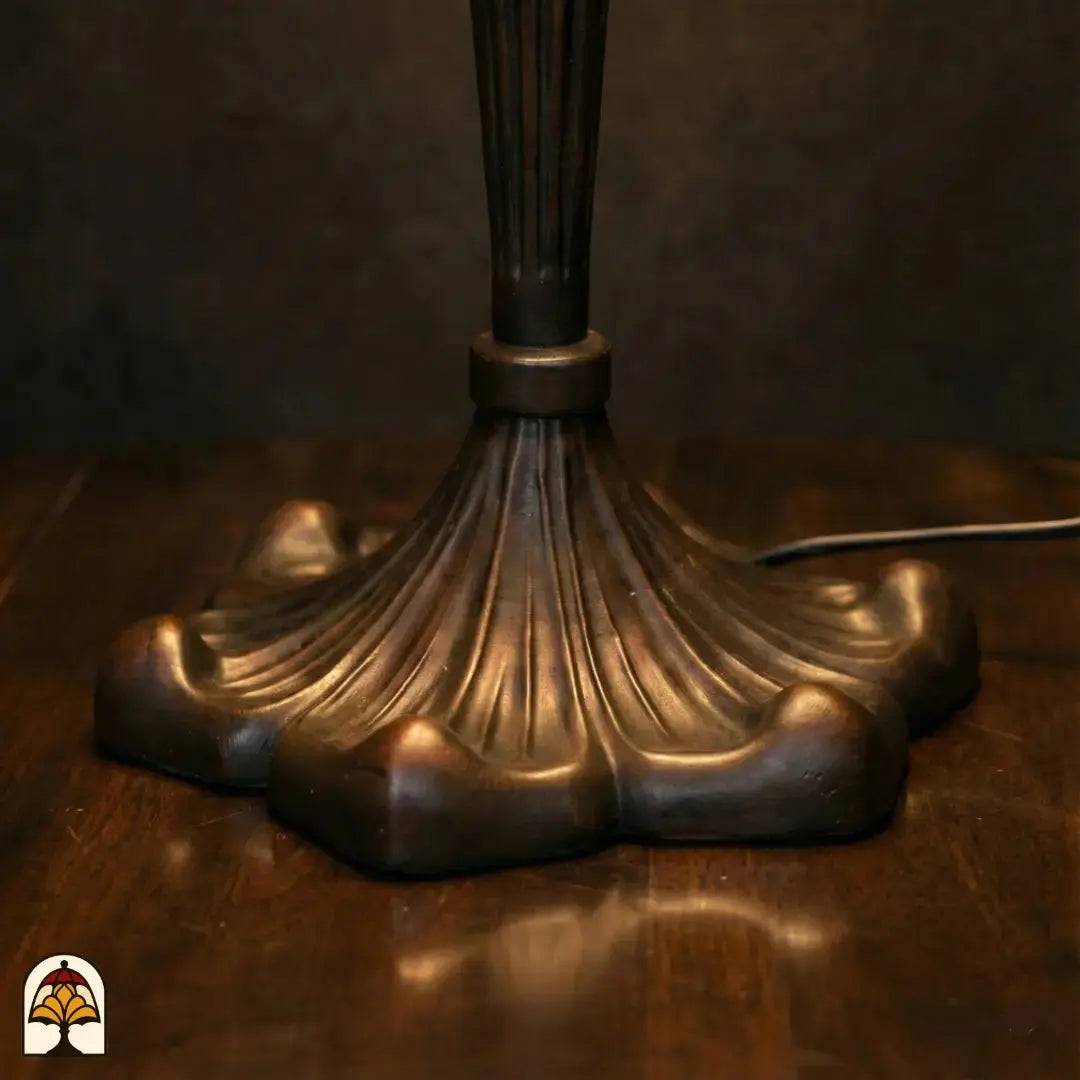 Gros plan base quadrilobée en bronze lampe de table Tiffany Alba Sereno à structure nervurée, câble d'alimentation visible
