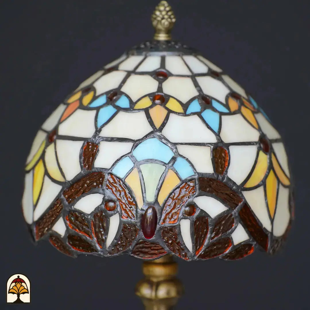 Gros plan abat-jour dôme éteint lampe de table Tiffany Baroque – verre crème et turquoise avec formes de feuilles baroques brunes et cabochon rouge