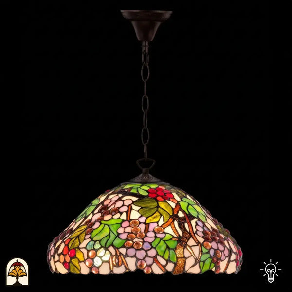 Suspension Tiffany Sylva Berria allumée sur chaîne en bronze, abat-jour en dôme à motifs de vigne, petites grappes de raisins rouges et grains de raisin lilas et roses et feuilles vertes en vitrail, fond sombre
