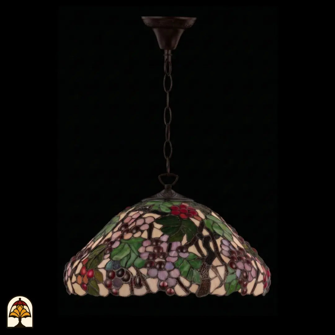 Suspension Tiffany Sylva Berria éteinte à chaîne en bronze sous un autre angle, abat-jour en dôme avec grappes de raisins lilas et rouges et feuilles vertes