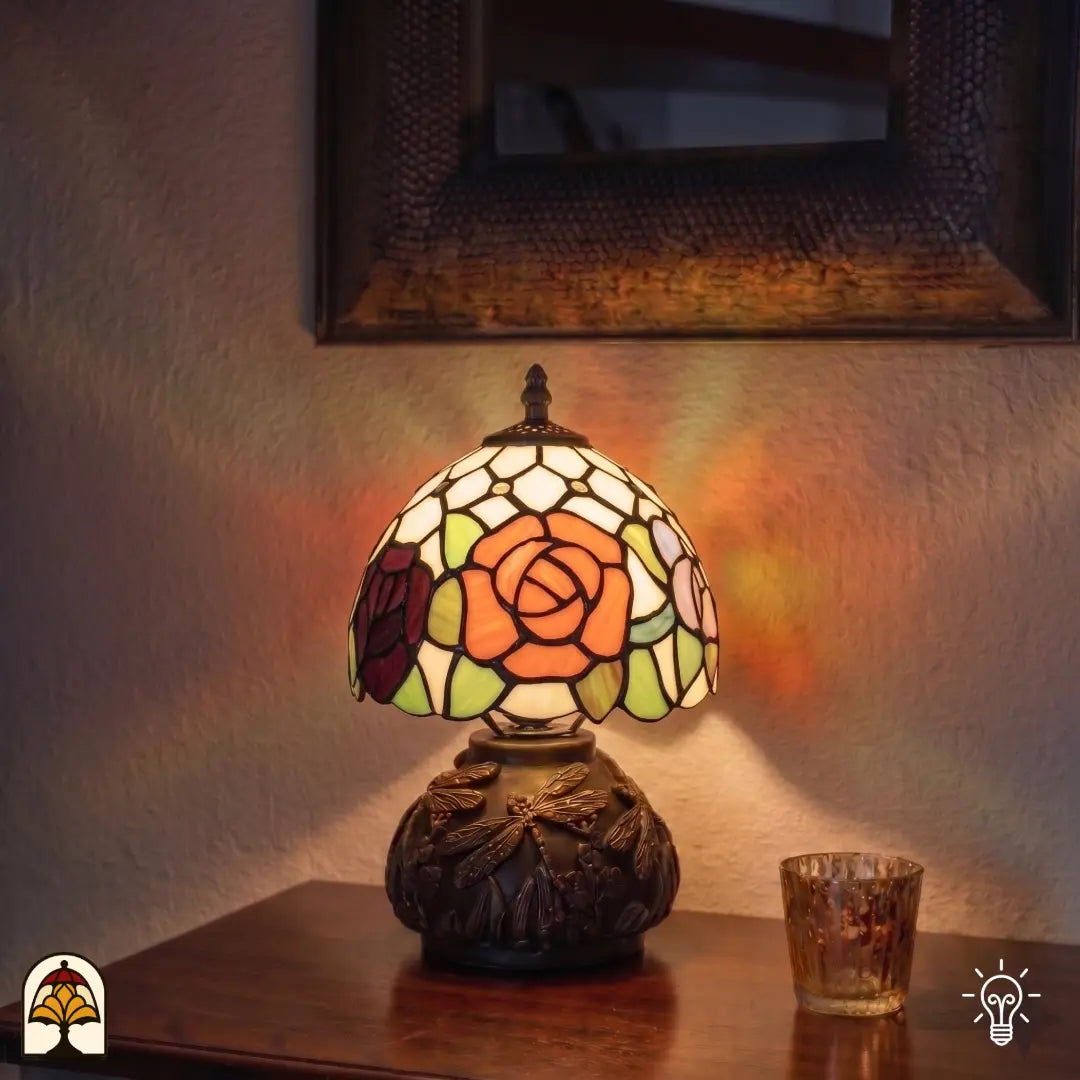 Lampe de table Tiffany Silvae Rosea allumée dans un intérieur – rose orange chaleureuse en vitrail