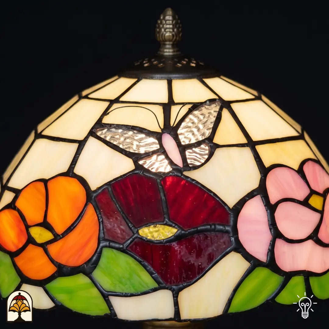 Gros plan abat-jour Papilio Reginae – fleurs orange, rouges et roses avec papillon en verre