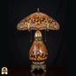 Tiffany lamp tafellamp onverlicht, koepelvormige kap met libellemotieven langs de rand en amberkleurig glas, blauw en groen-amber glaskralen, glas-in-lood peervormige voet en bronzen leeuwenpootvoet