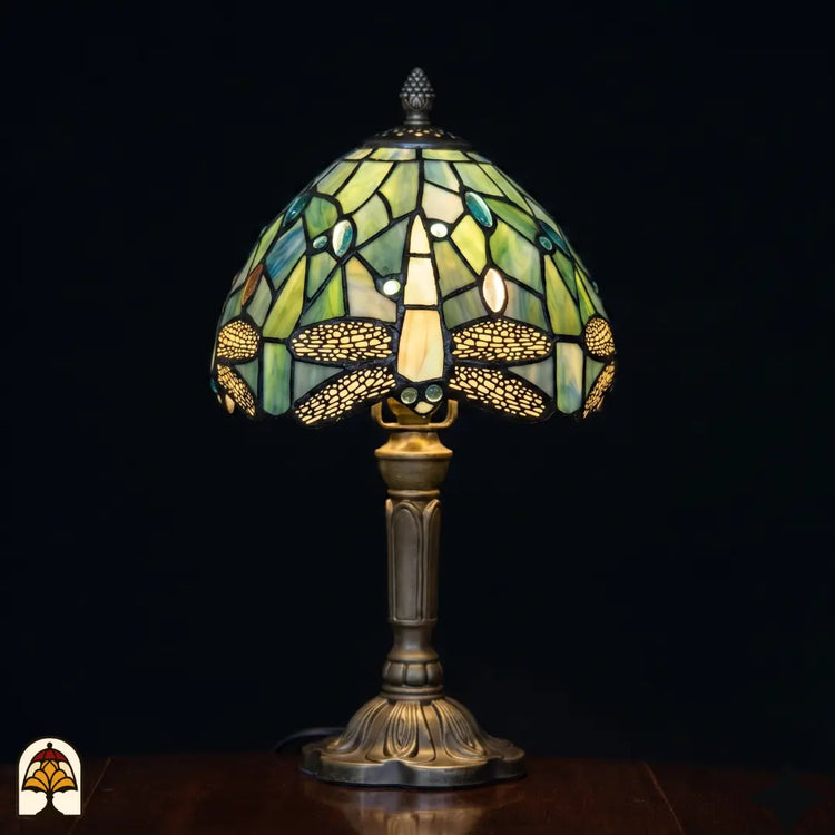 Verlichte Tiffany tafellamp Libellula Celeste ⌀20 cm op zwarte achtergrond – lichtblauwe koepelkap met libellenmotief, bronzen kolomvoet