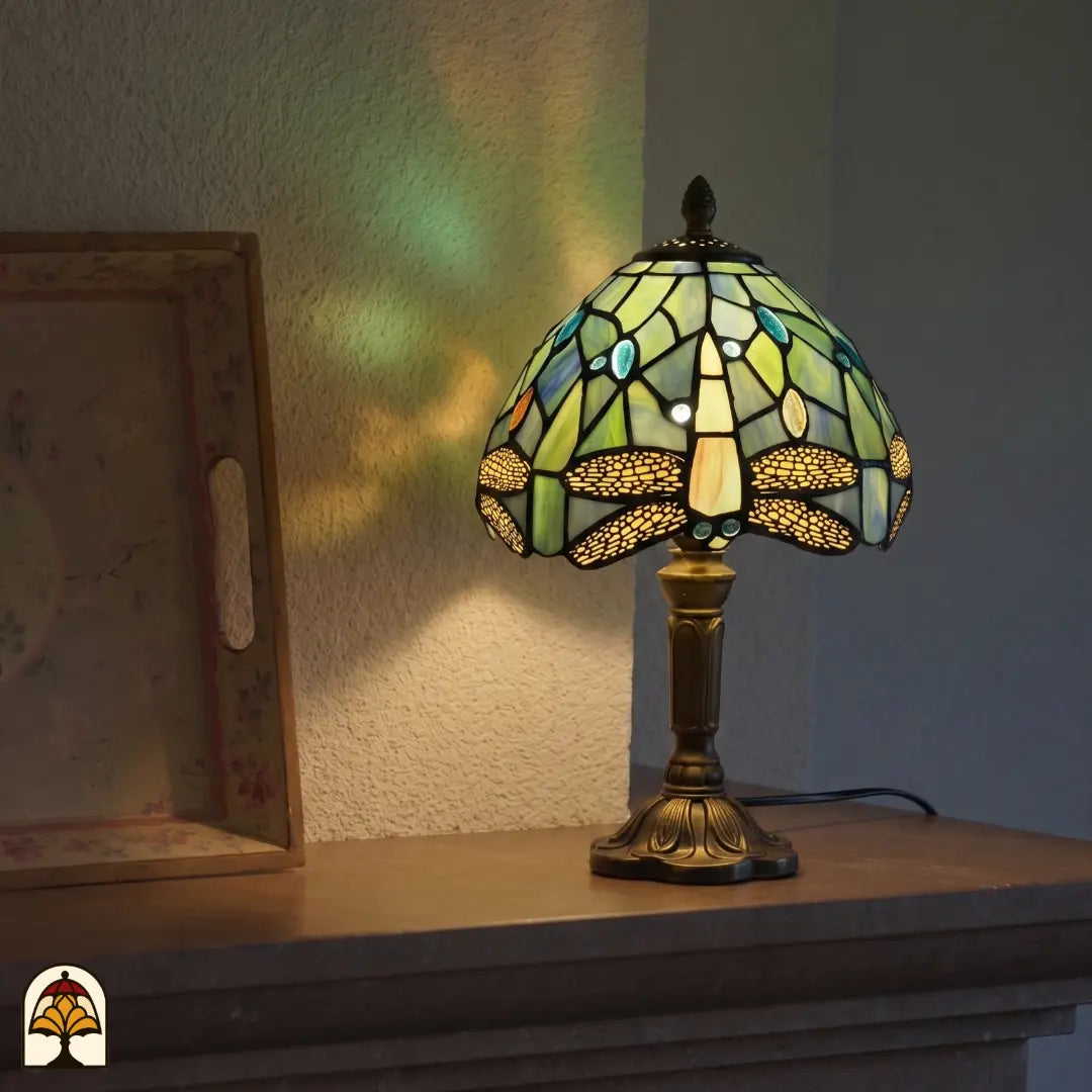 Lampe de table Tiffany Libellula Celeste ⌀20 cm allumée dans un intérieur chaleureux – abat-jour bleu clair à motif de libellule, lumière chaude, pied en bronze