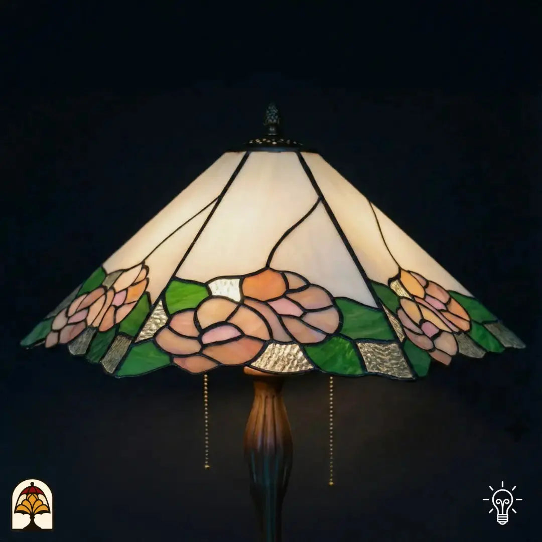 Gros plan abat-jour allumé lampe de table Tiffany Alba Sereno, partie supérieure blanche et crème, roses roses et feuilles vertes en bas, verre texturé, interrupteurs à chaînette visibles