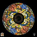 Bovenaanzicht verlichte koepelkap Tiffany tafellamp Florentia Blu, oranje-roze, blauw, groen en beige bladmotieven in glas-in-lood, centrale zwarte fitting zichtbaar