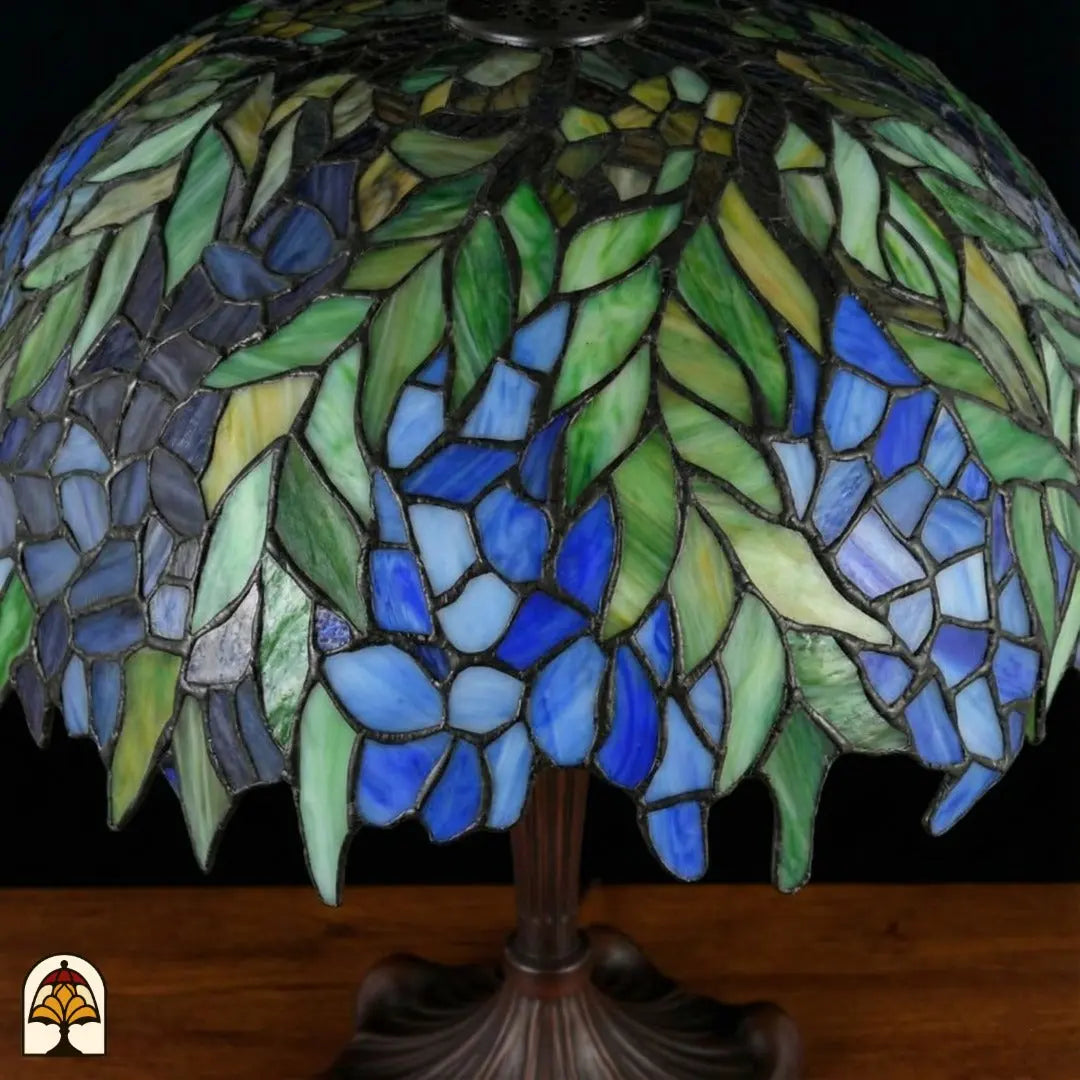 Gros plan abat-jour Tiffany éteint — feuilles vertes, fleurs bleues et violettes de style glycine