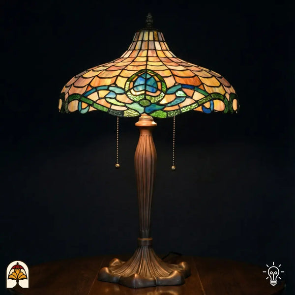 Grande lampe de table Tiffany allumée avec large abat-jour en forme de vasque à motif d'écailles ambrées, bordure Art nouveau turquoise/bleue et verte à motif de lotus, pied en bronze cannelé avec interrupteurs à chaînette, fond sombre