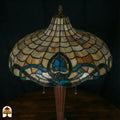 Close-up onverlichte Tiffany kap andere hoek — beige/amber schubpatroon, turquoise en blauwe lotusmotief rand
