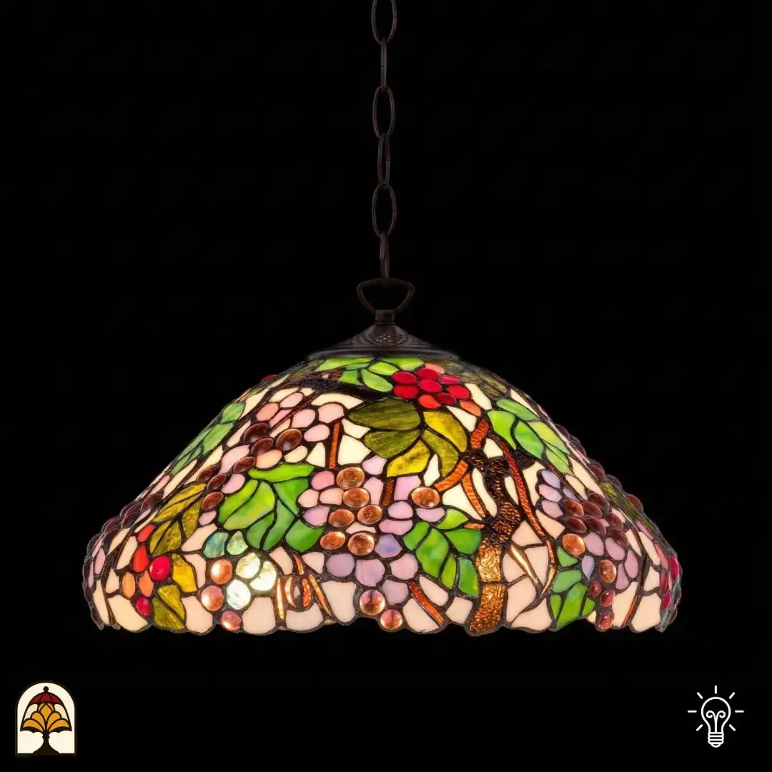 Suspension Tiffany Sylva Berria allumée, abat-jour en dôme à motifs de vigne, grains de raisin rouges, lilas et roses et feuilles vertes en vitrail, fond sombre