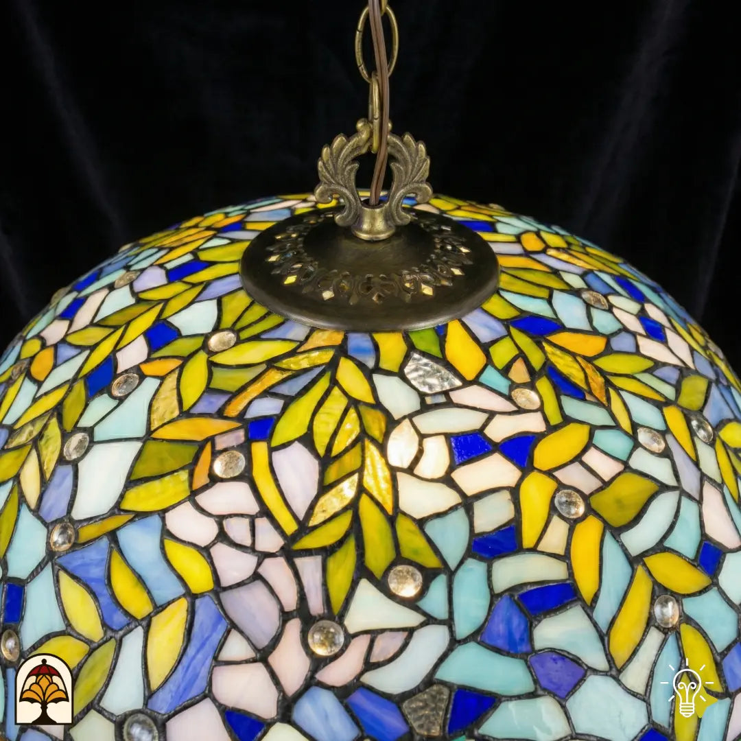Gros plan abat-jour Drizzle Bleu ⌀50 éteint vu de dessus, panneaux de vitrail bleus, turquoise et blancs avec motifs de feuilles jaunes, accents ronds en cristal, douille centrale en bronze