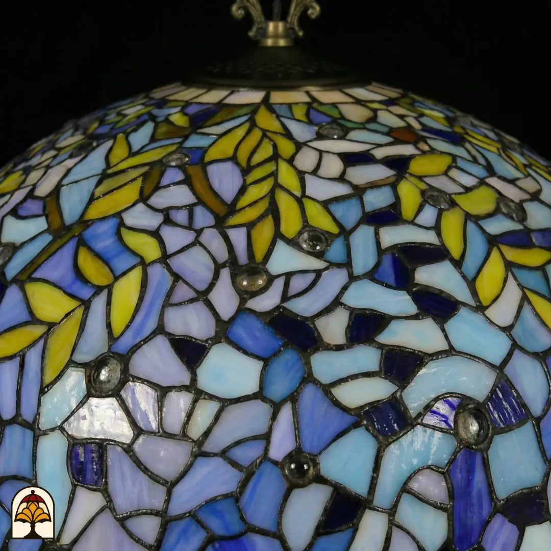 Gros plan abat-jour Drizzle Bleu ⌀50 éteint, panneaux de vitrail bleus, bleu clair et violets avec motifs de feuilles jaunes et accents ronds en cristal