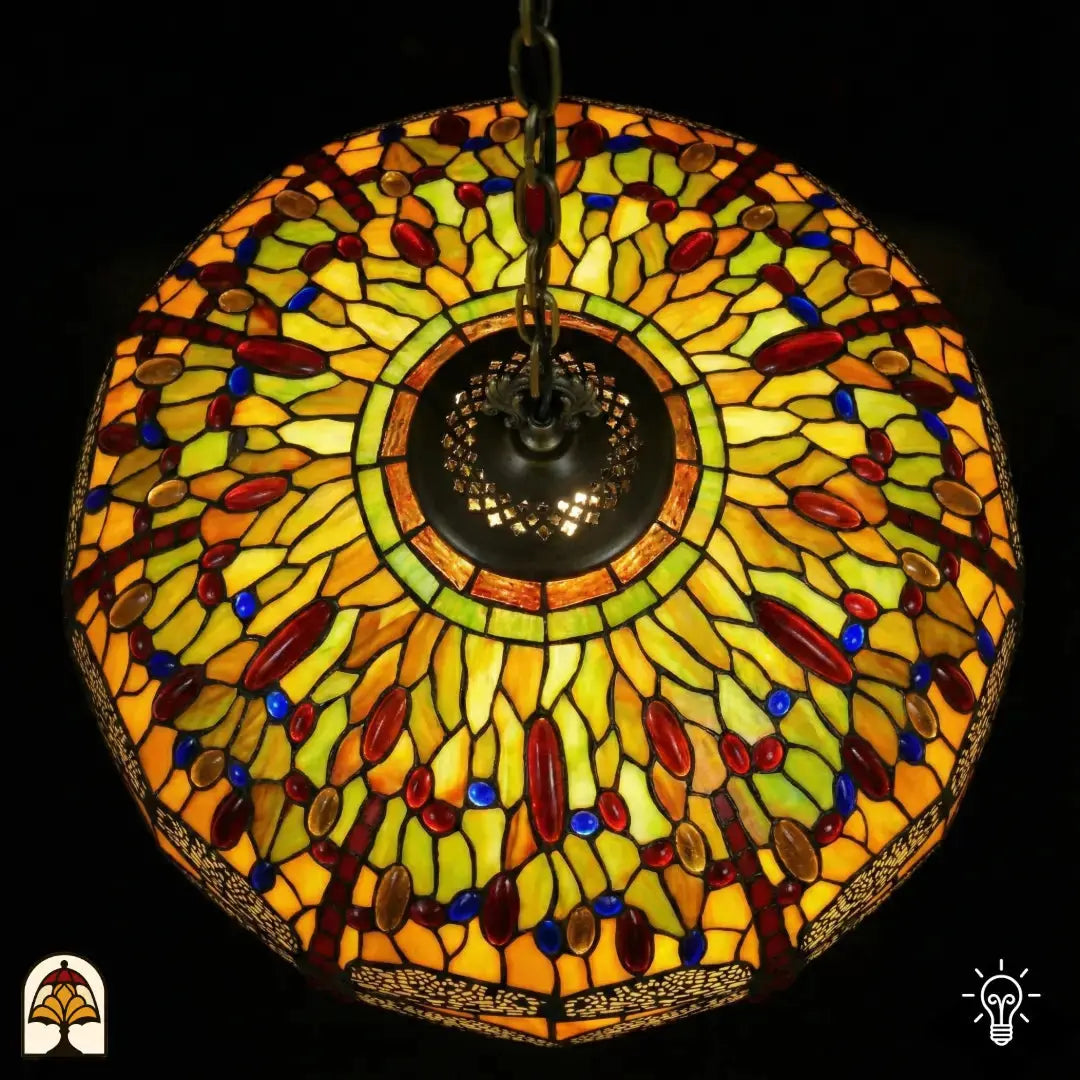 Vue de dessus abat-jour allumé Libellula Aurelia ⌀50, panneaux de vitrail jaunes et verts avec cabochons en verre rouges et bleus, frise de libellules, douille centrale en bronze