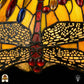 Close-up verlichte libellenmotief langs rand kap Libellula Aurelia ⌀50, amber-gele panelen, grijze libellenvleugels met rode juwelen