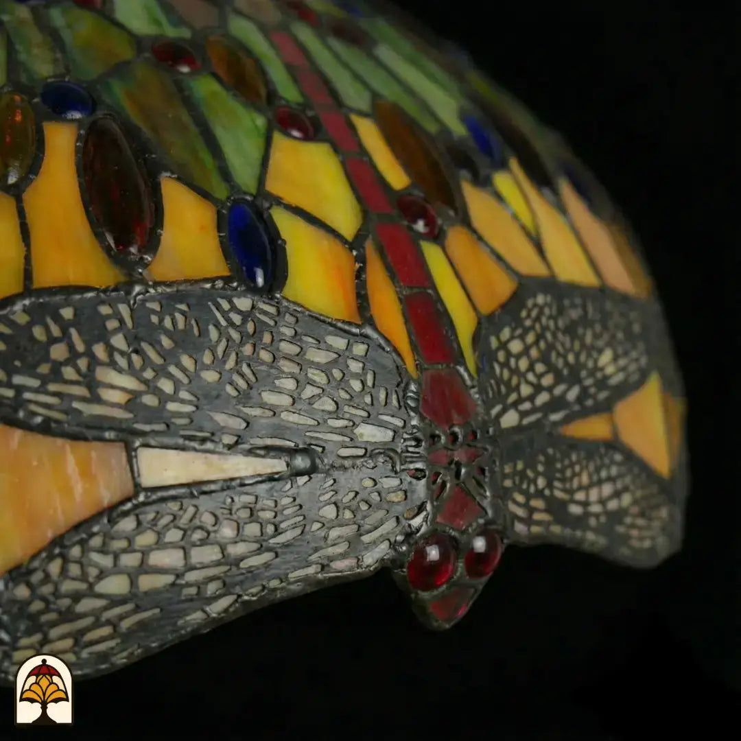 Gros plan du motif de libellules éteint le long du bord de l'abat-jour Libellula Aurelia ⌀50, panneaux jaunes, ailes de libellule grises avec cabochons rouges et accents en verre rouge