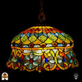 Tiffany lamp hanglamp verlicht van dichterbij, koepelvormige kap met ambergele bovenzone met groene glaskralen en roodbruine ovale kralen, onderzone met gele arabesken, lichtblauwe bloemvormige kralen en rode ronde kralen op transparant glas