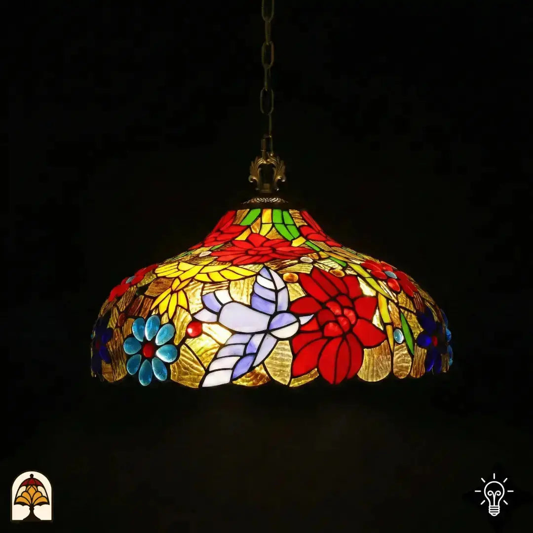 Suspension Tiffany allumée dans un environnement sombre, forme de dôme avec fleurs de poinsettia rouges, marguerites bleues, papillon blanc-lavande et panneaux de feuilles jaunes sur verre doré, suspendue à une chaîne en bronze avec douille en bronze