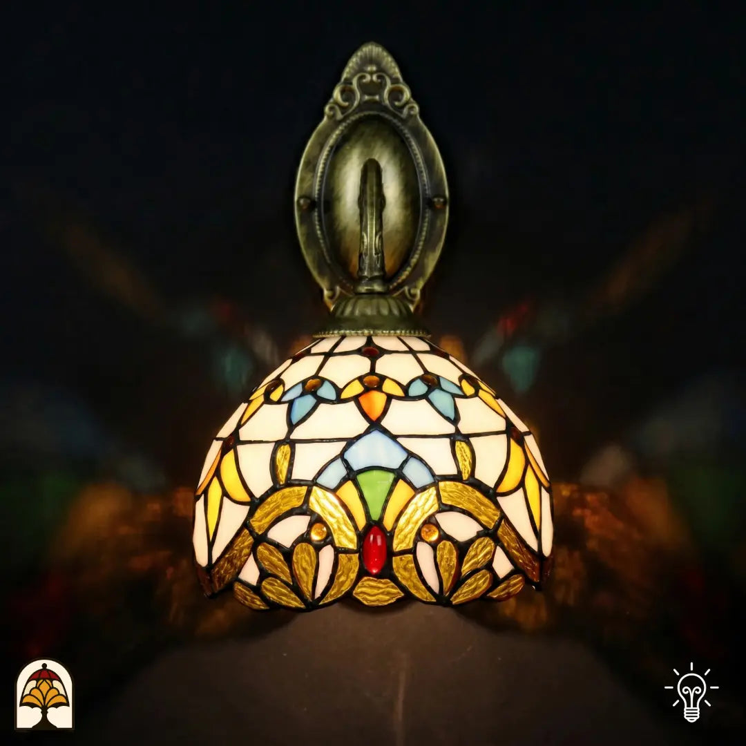 Vue de dessus applique murale Tiffany Barok avec platine murale ovale en bronze en haut et bras courbé, abat-jour à motif baroque en vitrail jaune doré
