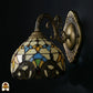 Onverlichte Tiffany wandlamp Barok van opzij met bronzen beugel, kap met barokke glas-in-lood stukken in goudgeel, blauw en rood