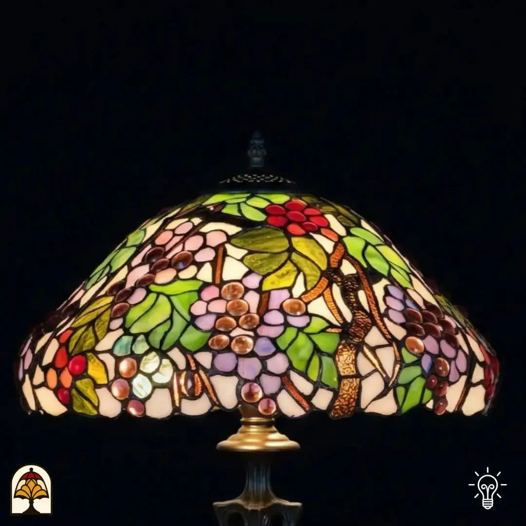 Gros plan abat-jour allumé lampe de table Tiffany Sylva Berria vue de dessous, motifs de vigne avec grappes de raisin rouges et lilas et feuilles vertes en vitrail