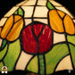 Close-up lampenkap Holland Golden Tulip – rode en gele tulpen met groene bladeren in glas