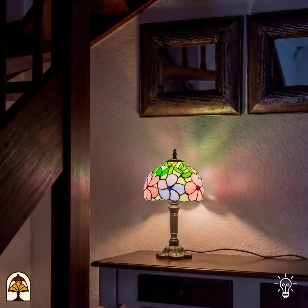 Lampe de table Tiffany Majestueuze Iris ⌀20 cm allumée dans un intérieur chaleureux – abat-jour en dôme avec iris roses et lilas, pied en bronze, ambiance pastel
