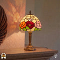 Tiffany tafellamp Papilio Reginae in interieur verlicht – bloemrijke tuin in glas-in-lood