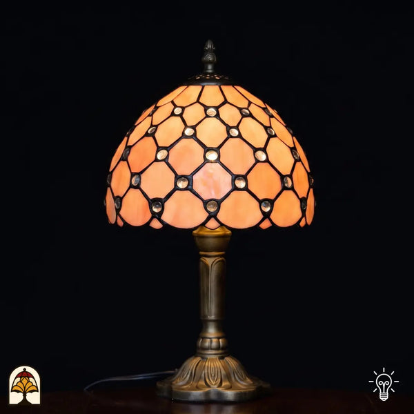 Lampe de table Tiffany Nuvola Rosa ⌀20 cm allumée – abat-jour sphérique dans un ton rose saumon doux avec motif de losanges et cabochons en verre