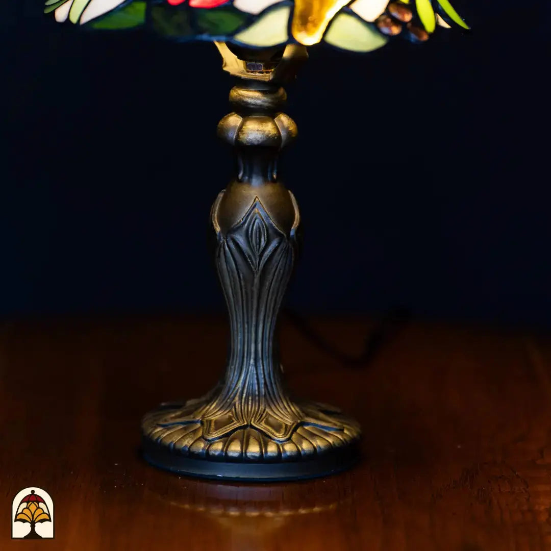 Gros plan pied — pied chandelier classique en bronze avec décorations en forme de feuilles et base ronde cannelée, sur une surface en bois