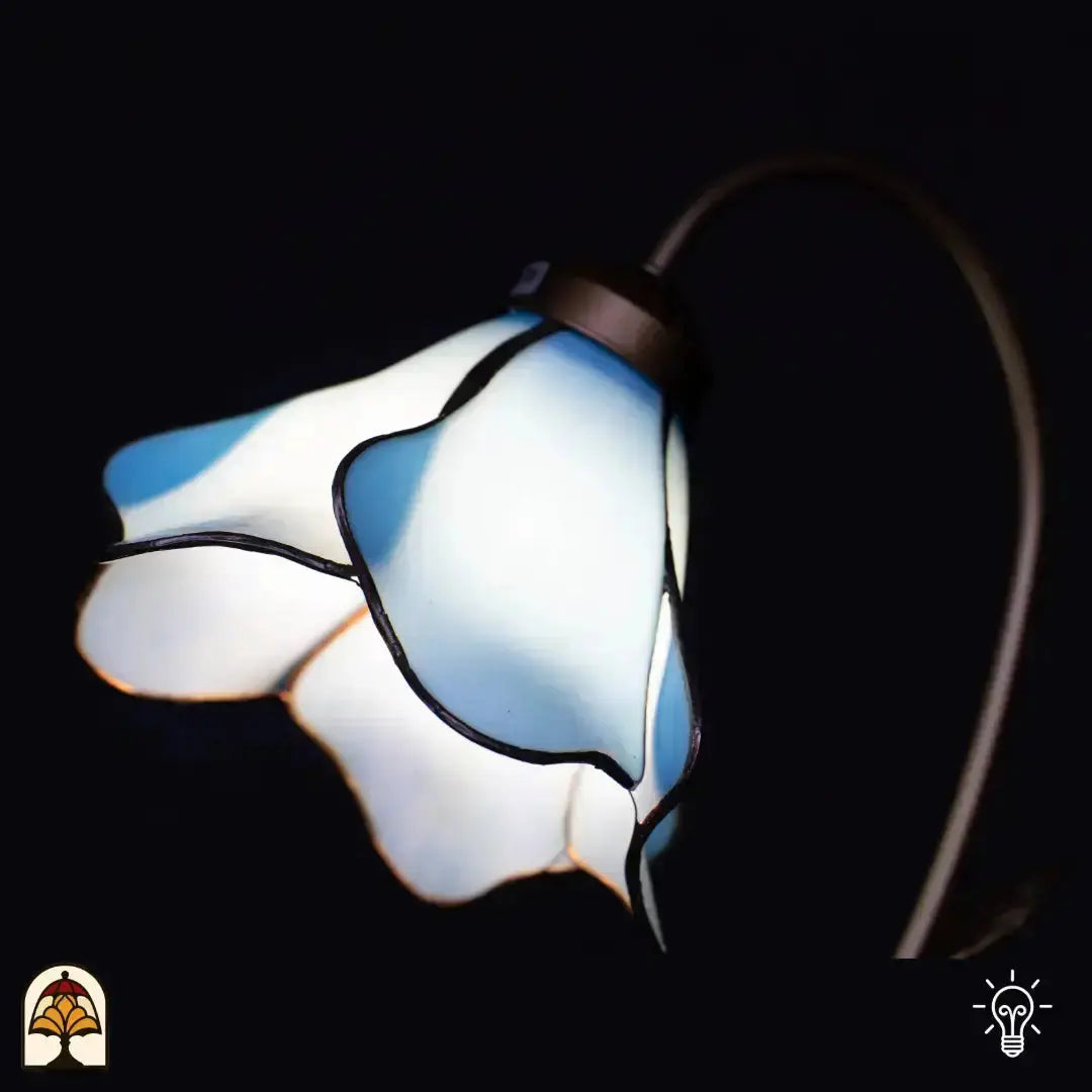 Gros plan abat-jour fleur de lotus bleu/blanc allumé — pétales en verre bleu et blanc déployés en éventail, éclairés de l'intérieur