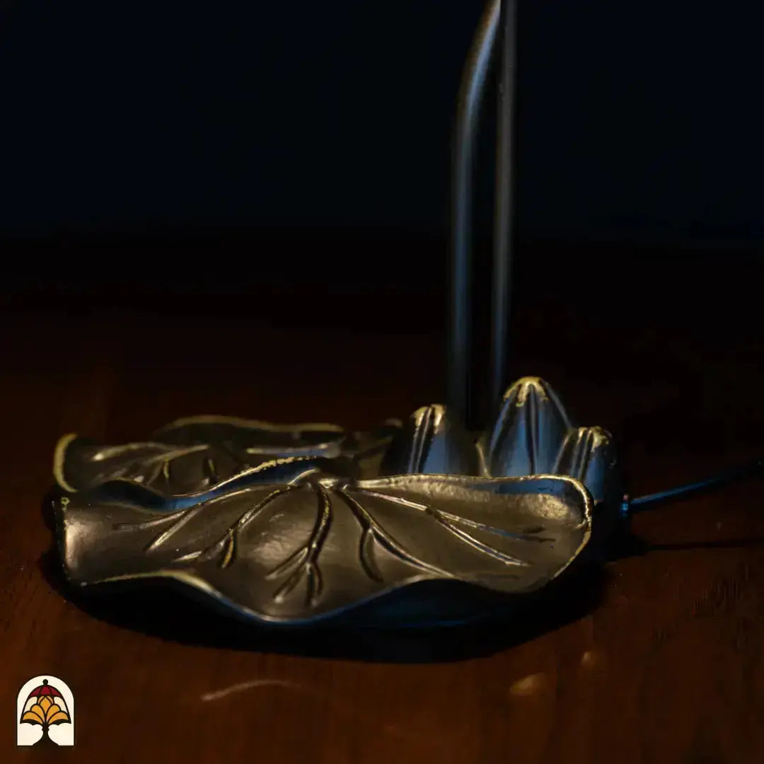 Gros plan du pied sous un autre angle — base en bronze doré en feuille de lotus avec petit bouton de fleur de lotus sur tige