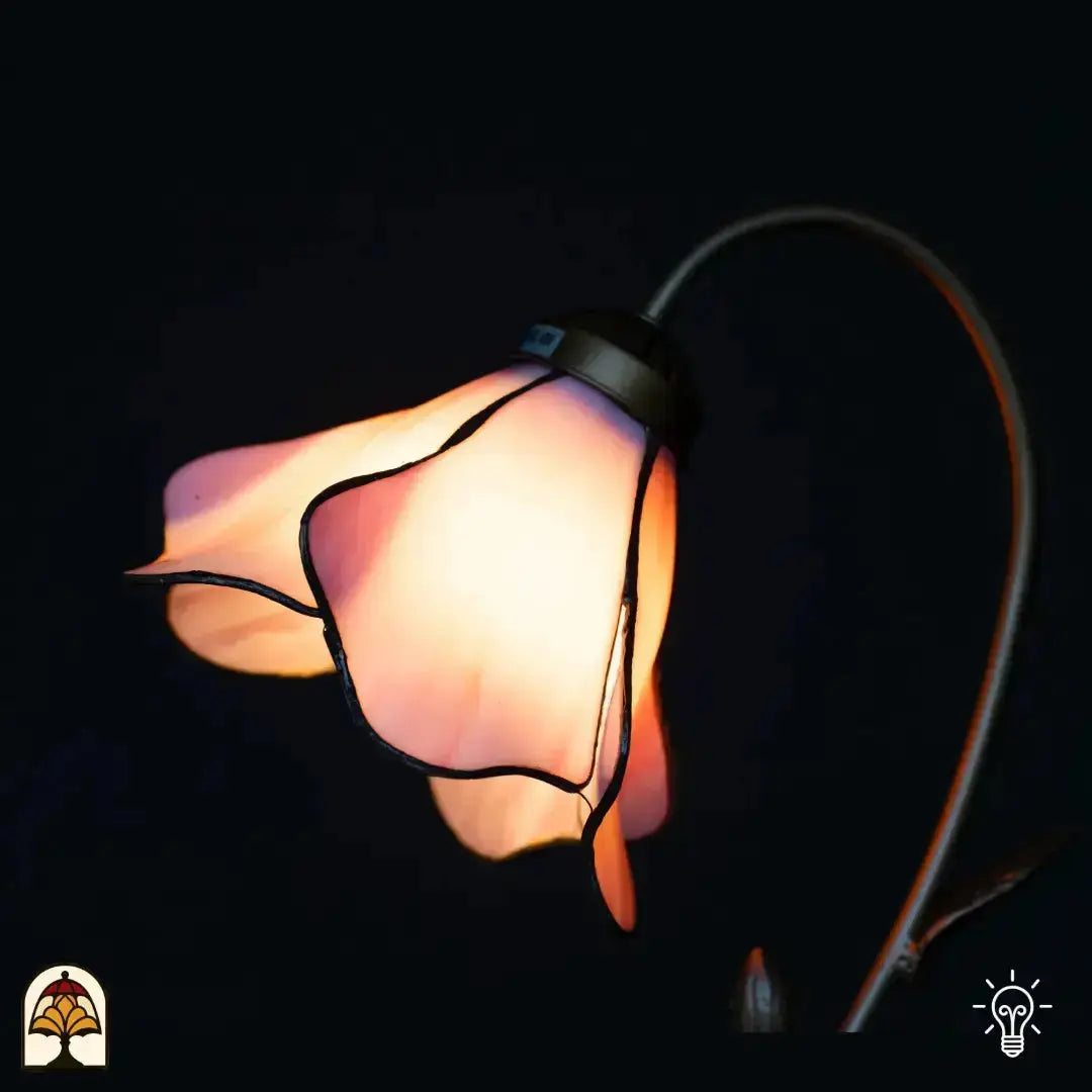Gros plan abat-jour fleur de lotus rose allumé — pétales en verre rose évasés éclairés de l'intérieur