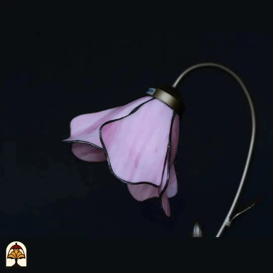 Gros plan abat-jour fleur de lotus rose éteint — pétales en verre rose déployés en éventail, fond sombre