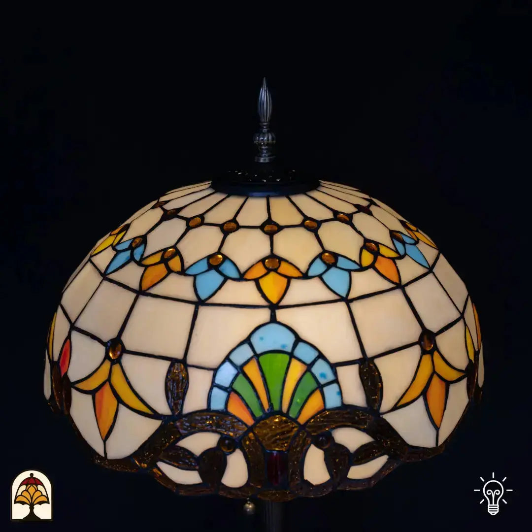Gros plan abat-jour lampadaire Tiffany Barok sous un autre angle — haut crème avec formes de tulipes bleues et orange, motif d'éventail vert en bas, bordure décorative en bronze