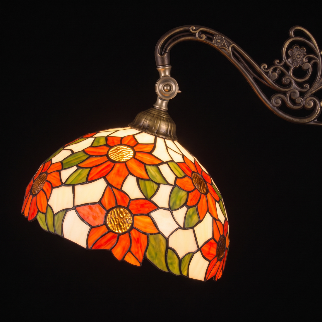 Tiffany vloerlamp Solea Leeslamp ⌀30 cm – close-up verlichte kap met gouden amberkleurige bloemharten en sierlijke boog