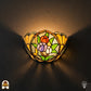 Tiffany wandlamp Tulipa Tricolore verlicht op muur – drie tulpen in rood, paars en wit in halfronde kap