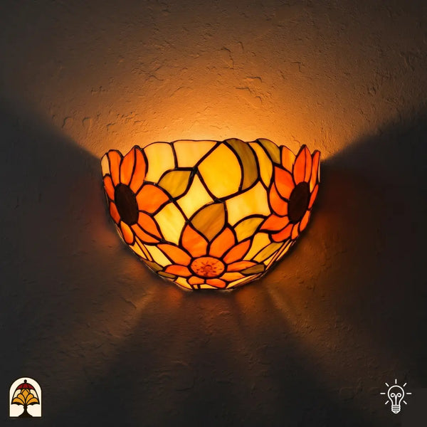 Applique murale Tiffany Solea Girasole allumée sur le mur – abat-jour demi-rond avec tournesols en verre orange et jaune